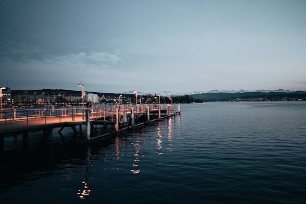 Illuminated boat dock on a lake at dusk with professional lighting