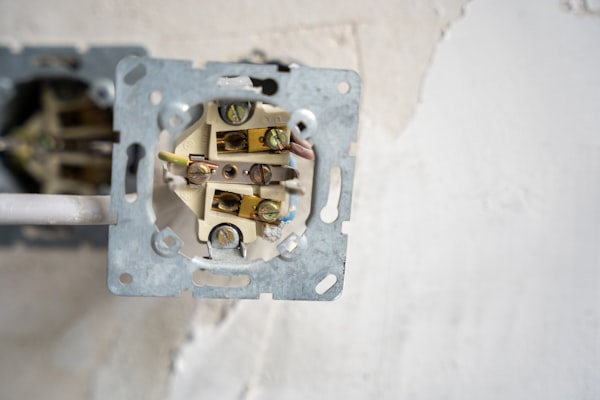 Disassembled electrical outlet showing wiring during residential repair